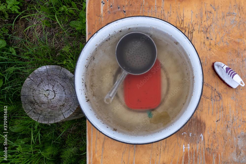 old table standing in a long hall and on which is placed a bowl of water, in which the dishes have been standing for a long time old table standing in a long hall and on which is placed a bowl of water, in which the dishes have been standing for a long time