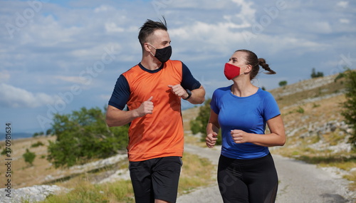 couple running in nature wearing mask