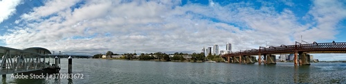 Beautiful panoramic view of a wharf and a railway bridge across a river on a sunny day with deep blue sky  Parramatta river  Meadowbank  Sydney  New South Wales  Australia 