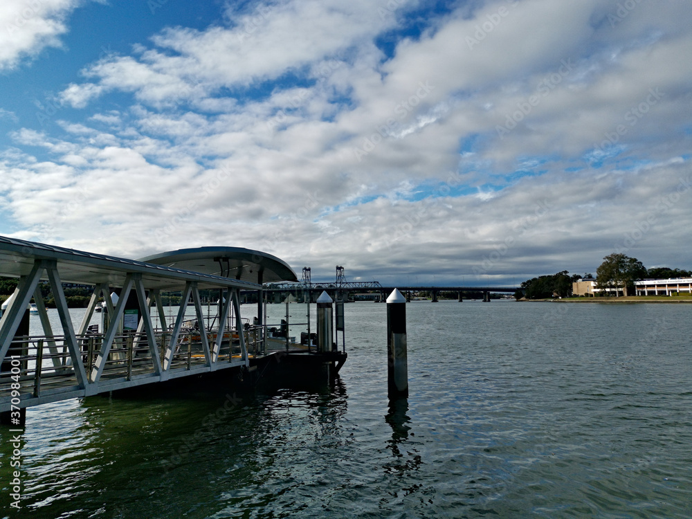 Beautiful view of a wharf along a river on a sunny day with deep blue sky and light clouds, Parramatta river, Meadowbank, Sydney, New South Wales, Australia
