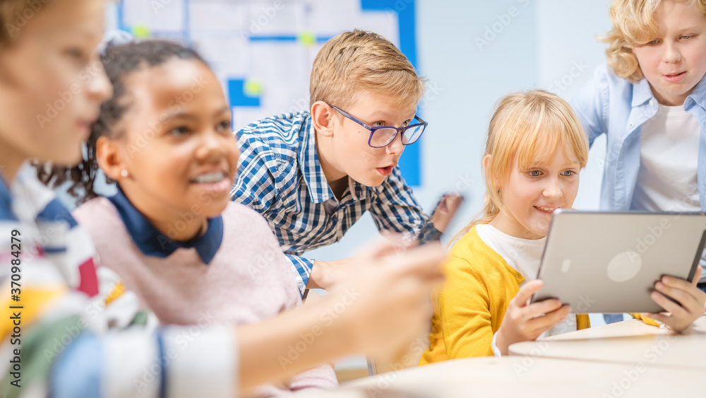 Elementary School Computer Science Class: Children Use Digital Tablet Computers and Smartphones with Augmented Reality Software, They’re Excited, Full of Wonder. Children in STEM, Playing and Learning Elementary School Computer Science Class: Children Use Digital Tablet Computers and Smartphones with Augmented Reality Software, They’re Excited, Full of Wonder. Children in STEM, Playing and Learning
