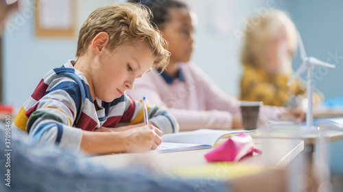Fotografía In Elementary School Classroom Brilliant Caucasian Boy Writes in Exercise Notebook, Taking Test and Writing Exam