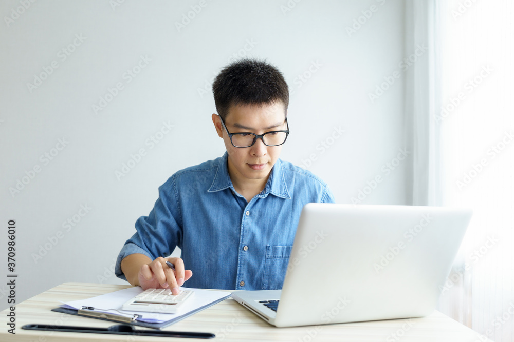 Work from home young Freelancer or Businessman working at home office with smartphone tablet. Working Online Or Studying And Learning While. Freelance Work, Business and Work from home concept Work from home young Freelancer or Businessman working at home office with smartphone tablet. Working Online Or Studying And Learning While. Freelance Work, Business and Work from home concept
