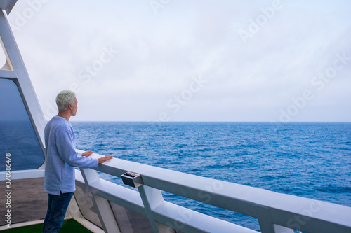 one young man i a ship or boat looking and enjoying the sea or ocean - vacations and holiday in summertime lifestyle - nomad people traveling in the canary island having fun