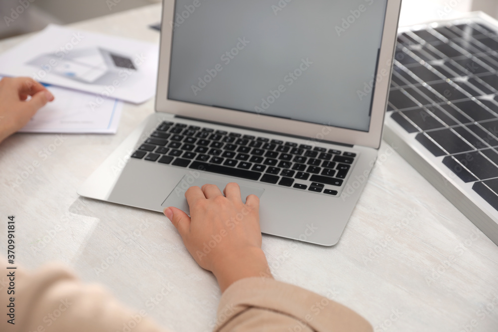 Woman working on project with solar panels at table in office, closeup Woman working on project with solar panels at table in office, closeup