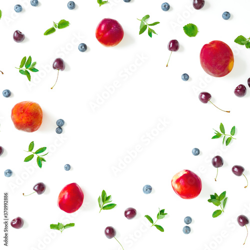 Fototapeta Naklejka Na Ścianę i Meble -  Peaches with cherry, blueberry and mint leaf on white background. Summer food frame. Top view.