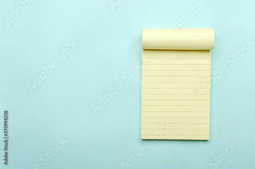 Top view of new blank notepad on the blue background.Empty space for text