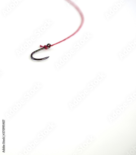 Fishing hook with red rope on white background, with empty space.