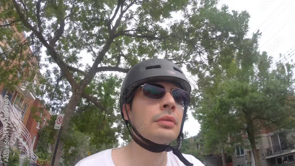 Young man taking a bike ride on his bicycle in the city. POV view of his face and torso.