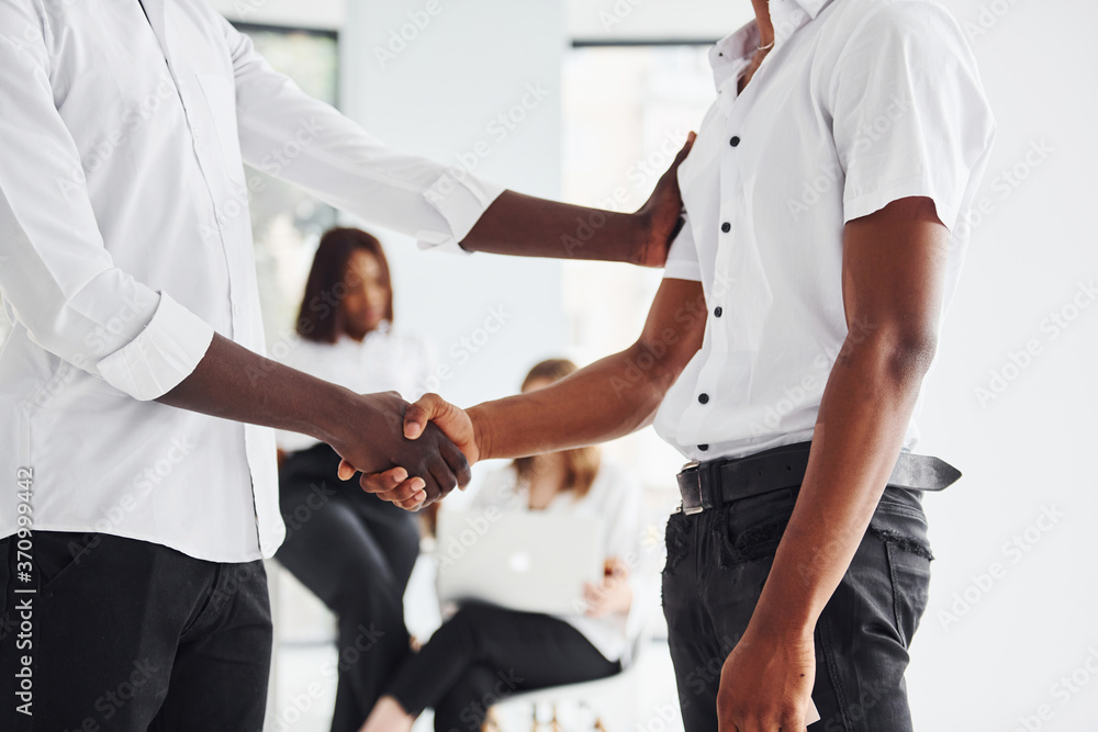 Doing handshake. Successful deal. Group of african american business people working in office together Doing handshake. Successful deal. Group of african american business people working in office together