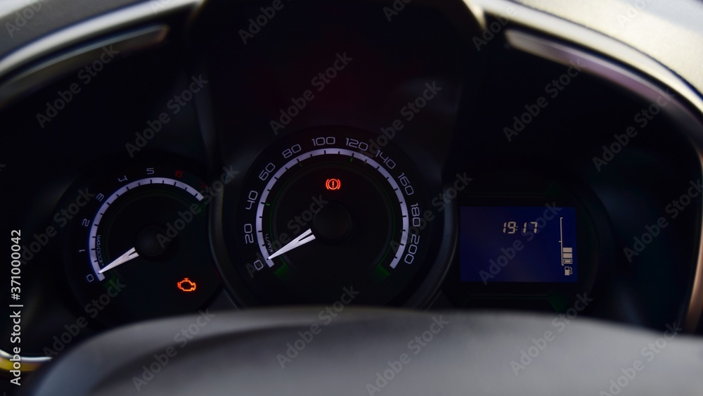 instrument panel in the car, where the radiator of the handbrake and engine are lit. close-up dark background. instrument panel in the car, where the radiator of the handbrake and engine are lit. close-up dark background.