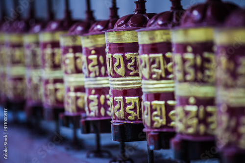 A row of buddhist prayer wheels in the Himalayas, Nepal