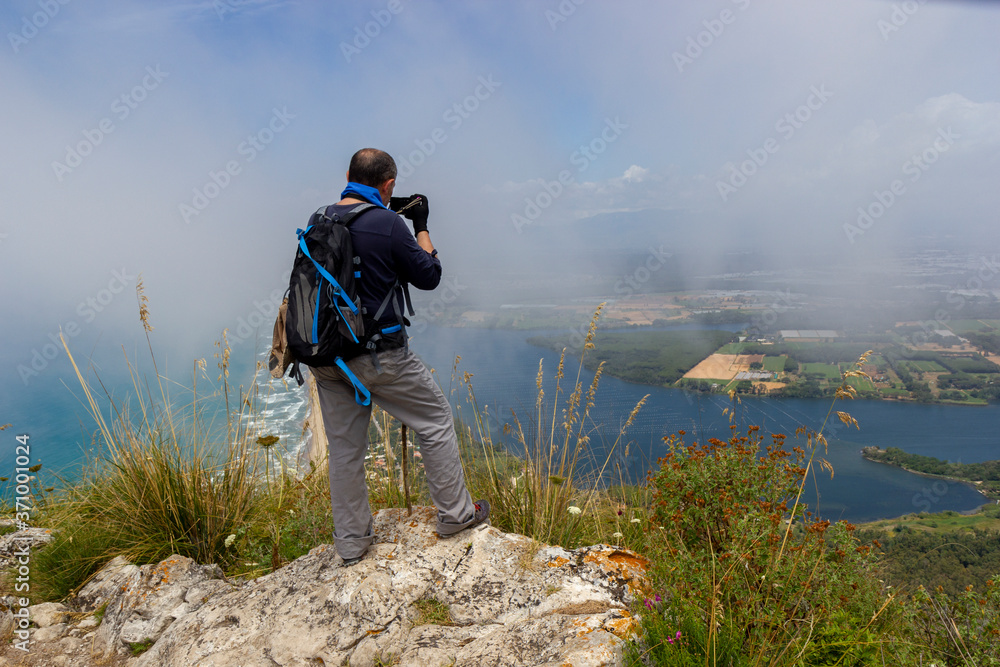 hiker on mountain peak with sea below in circeo national park