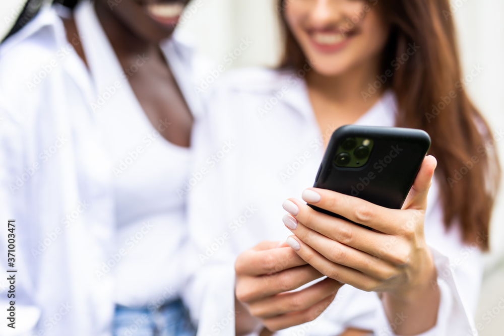 Beautiful mixed race women using a mobile in the Street. Youth concept. Beautiful mixed race women using a mobile in the Street. Youth concept.