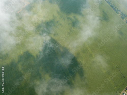 High flight in the clouds over agricultural fields.