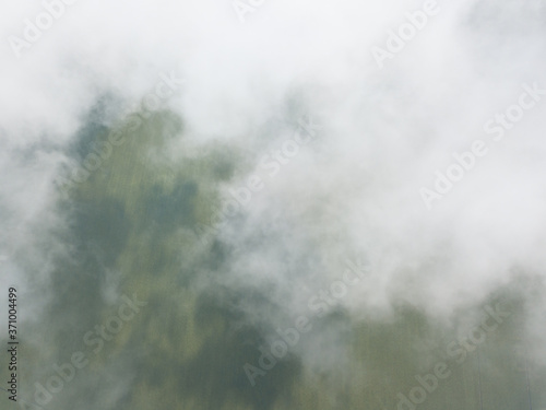 High flight in the clouds over agricultural fields.