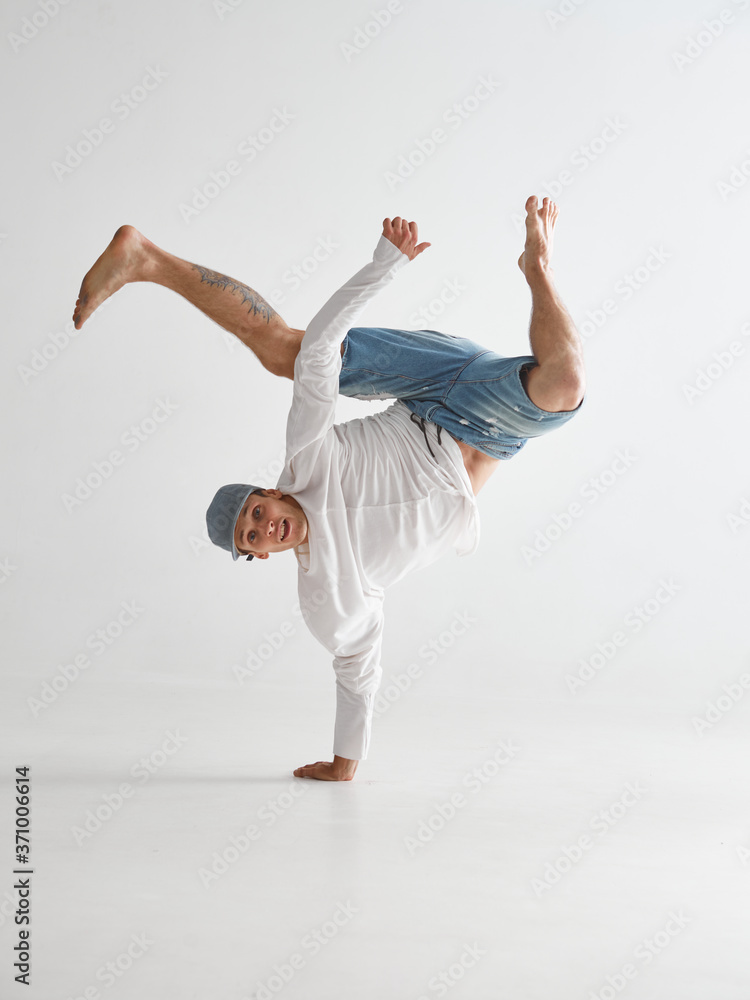 Young breakdancer stands on one arm dancing hip-hop isolated on white background. Break dance school poster