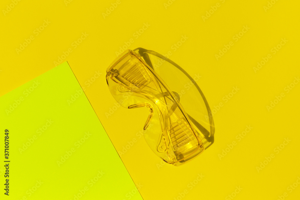 Transparent tinted glasses on yellow background. Creative monochrome layout.