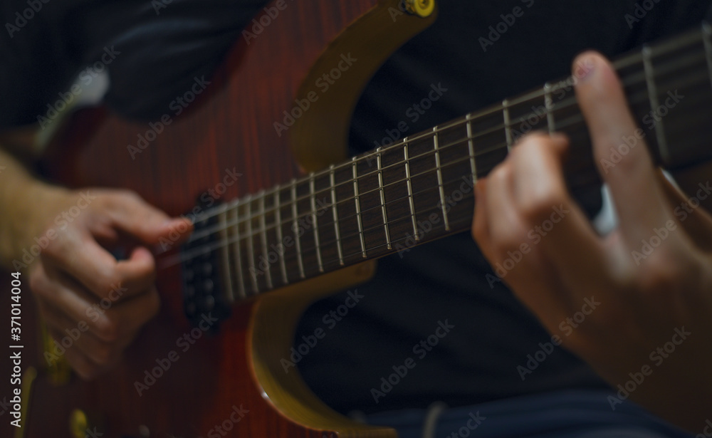 Close up of man's hands playing electric guitar. Musical instrument for recreation or hobby passion concept.