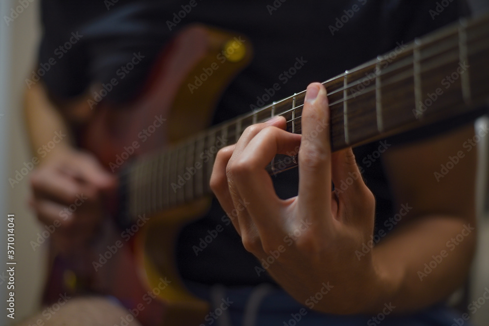 Close up of man's hands playing electric guitar. Musical instrument for recreation or hobby passion concept.