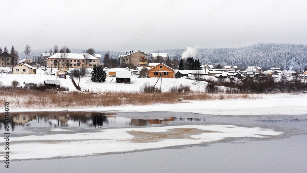 Panorama of the village on the river bank in winter