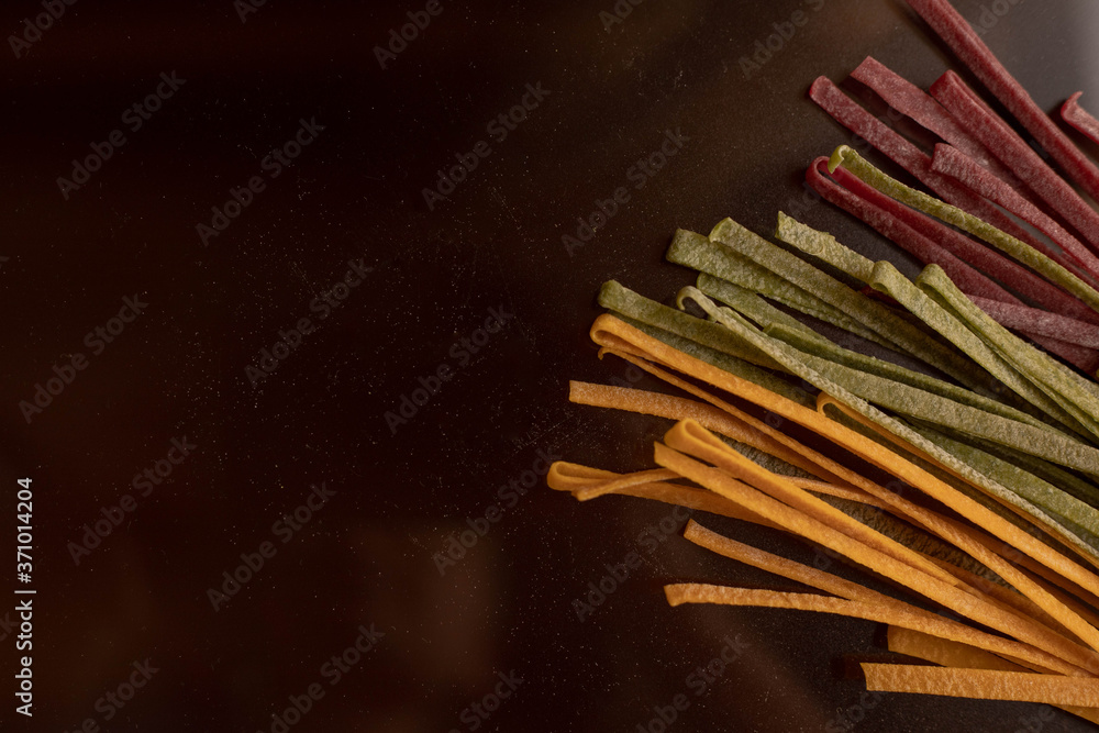 Dry pasta of different colors, yellow with turmeric, pink with storm, green with spinach, Italian cuisine, telanatelle Dry pasta of different colors, yellow with turmeric, pink with storm, green with spinach, Italian cuisine, telanatelle