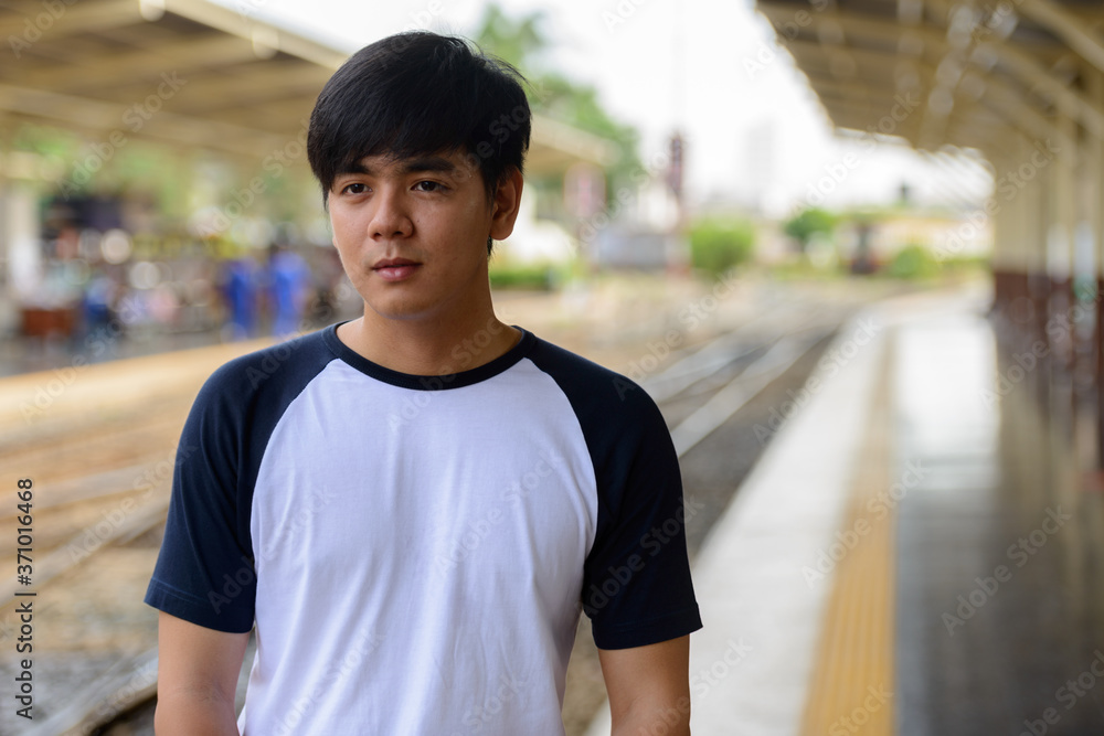 Young handsome Asian tourist man at the railway station Young handsome Asian tourist man at the railway station