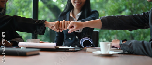 Photography Businesspeople are greeting each other with hand bumping while sitting at the meeting table