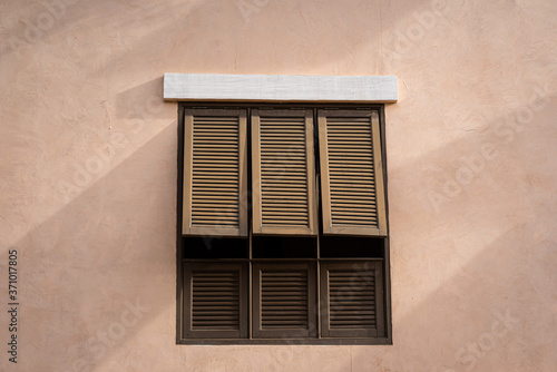 Classic style wooden window on the pink color pastel building.