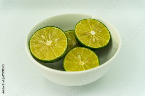 whole and half with slice of fresh green lime isolated on white background. Fresh and real tropical fruit.