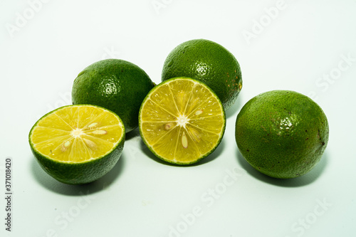 whole and half with slice of fresh green lime isolated on white background. Fresh and real tropical fruit.