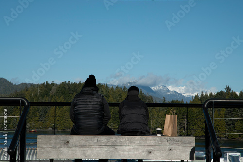 A couple sitting on a bench and observing the view in Vancouver Island, Tofino