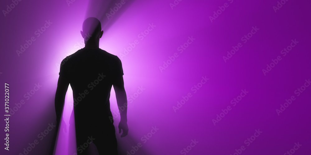 The man is standing. Ultraviolet spotlight behind the silhouette.