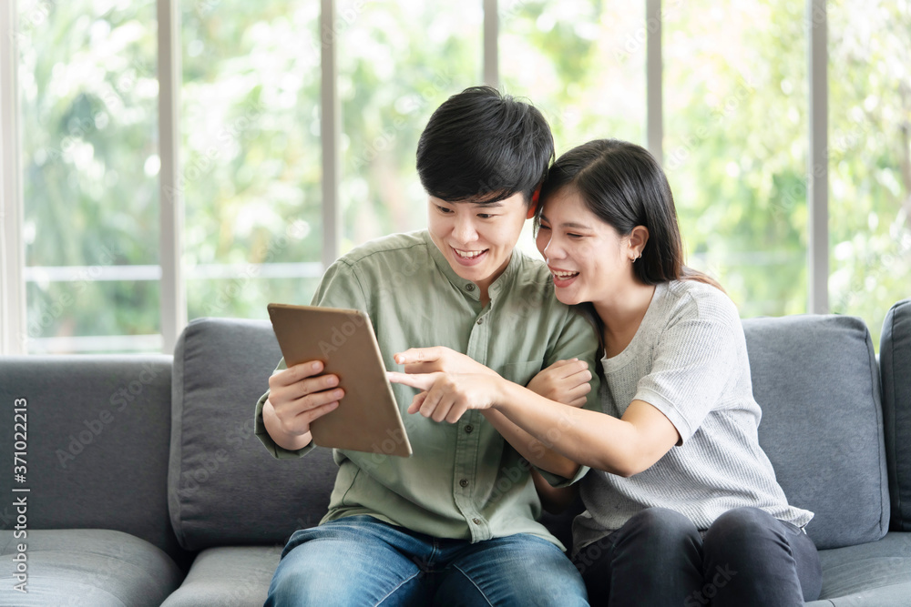 Asian LGBT Lesbian Couple Watching Tablet Screen on the Sofa Asian LGBT Lesbian Couple Watching Tablet Screen on the Sofa