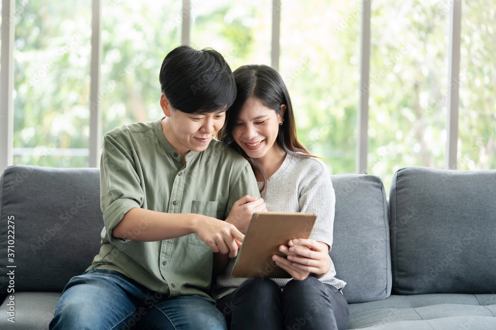 Asian LGBT Lesbian Couple Watching Tablet Screen on the Sofa Asian LGBT Lesbian Couple Watching Tablet Screen on the Sofa
