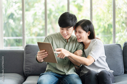 Asian LGBT Lesbian Couple Watching Tablet Screen on the Sofa