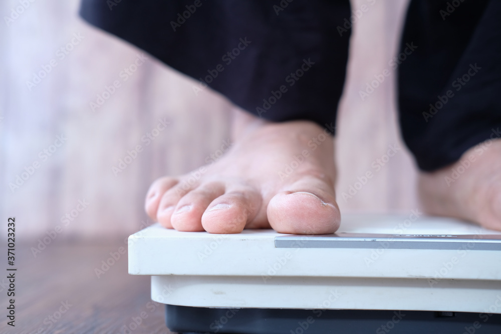 woman's feet on weight scale close up.