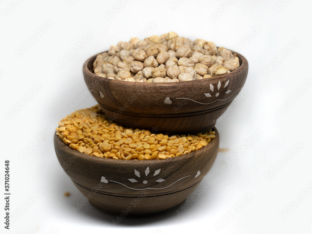 White Chick Pea and yellow lentils isolated in wooden bowl on White Background White Chick Pea and yellow lentils isolated in wooden bowl on White Background