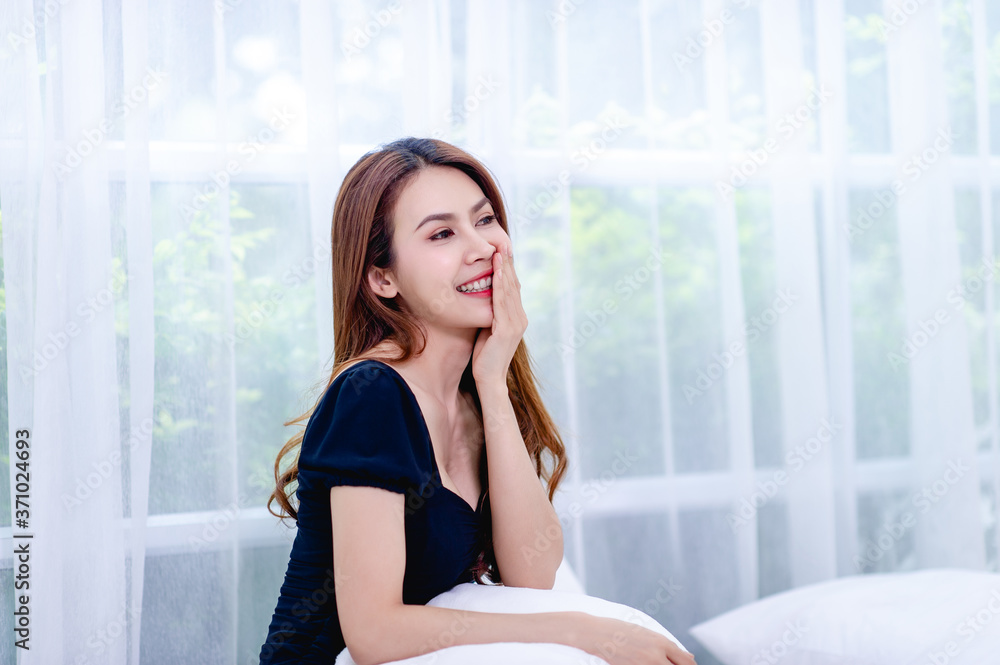 A woman smiling happily In the white bedroom The concept of living a happy life A woman smiling happily In the white bedroom The concept of living a happy life