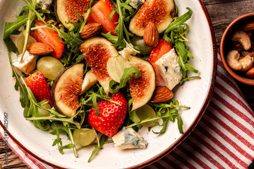 Diet menu. Healthy salad of fresh Fig  arugula  strawberries  grapes  blue cheese salad  Flat lay. Top view