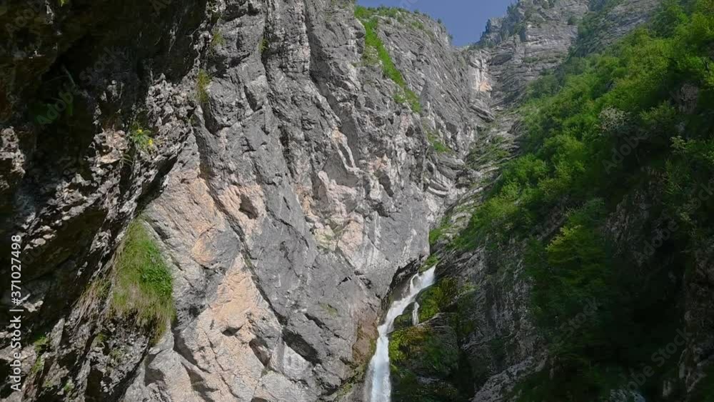 Pristine waterfall flowing downstream in Alps mountain. Close up view of raging waterfall Savica in Slovenia. Rocks covered with moss. Pristine and clean nature. Wild nature. Slow motion, tilt down Pristine waterfall flowing downstream in Alps mountain. Close up view of raging waterfall Savica in Slovenia. Rocks covered with moss. Pristine and clean nature. Wild nature. Slow motion, tilt down