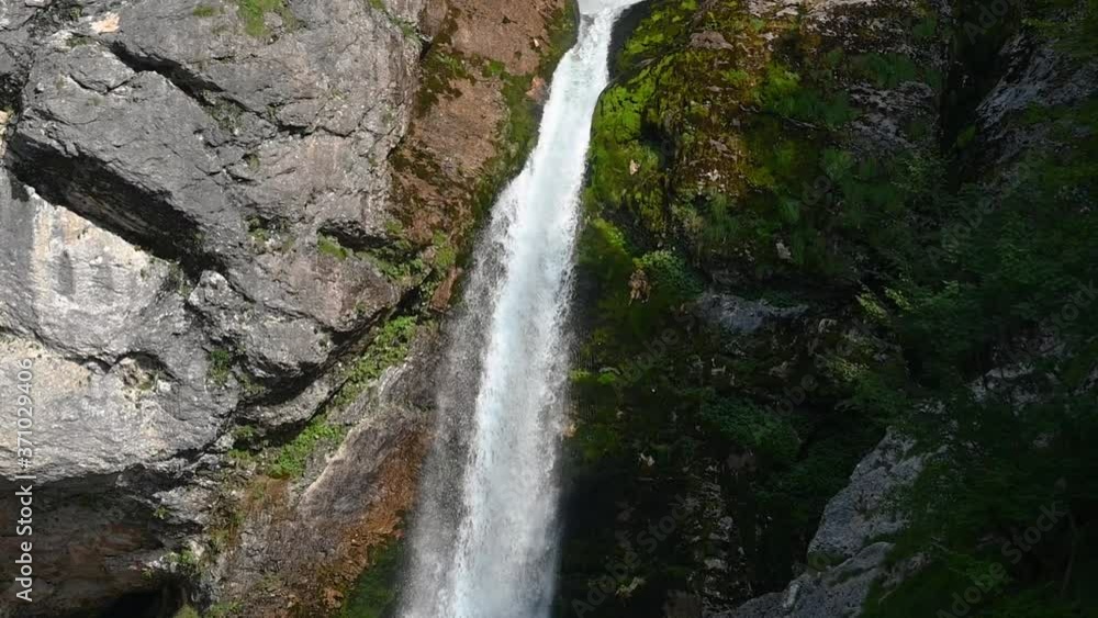 Pristine waterfall flowing downstream in Alps mountain. Close up view of raging waterfall Savica in Slovenia. Rocks covered with moss. Pristine and clean nature. Wild nature. Slow motion, tilt down Pristine waterfall flowing downstream in Alps mountain. Close up view of raging waterfall Savica in Slovenia. Rocks covered with moss. Pristine and clean nature. Wild nature. Slow motion, tilt down
