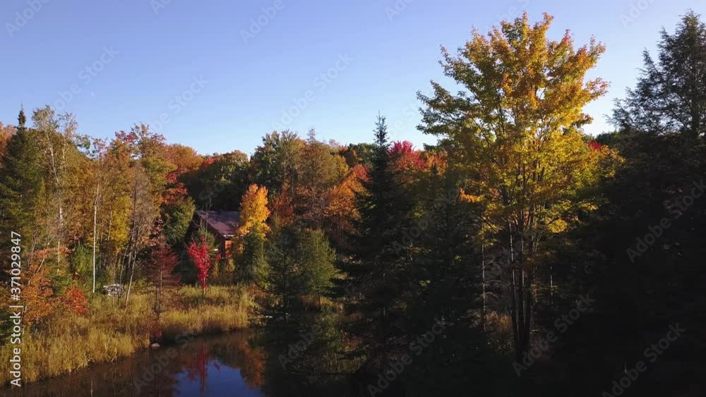 Panning from left to right in the country on a sunny day of Autumn with bright and colorful trees by the lake Panning from left to right in the country on a sunny day of Autumn with bright and colorful trees by the lake