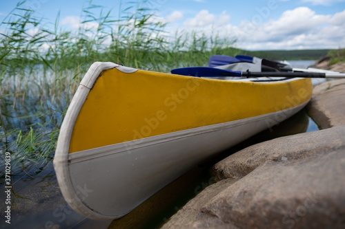 Yellow Kayak on the lake at summer day. No people around.