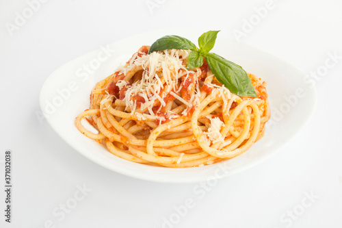 Closeup on italian pasta with tomato sauce and parmesan in the plate on the white surface