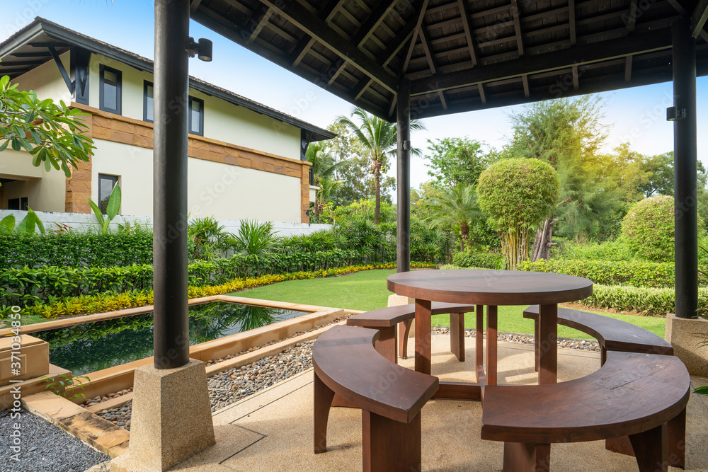 Exterior design of house, home feature garden landscape with outdoor table and chair in pavilion and swimming pool