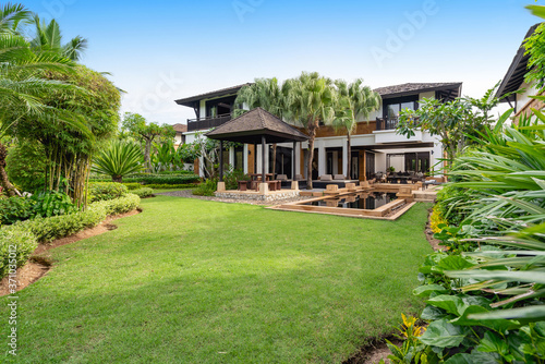 Exterior design of pool villa feature yard green garden and big tree © korakoch
