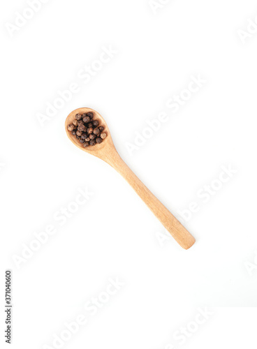 Wooden spoon and black pepper isolated