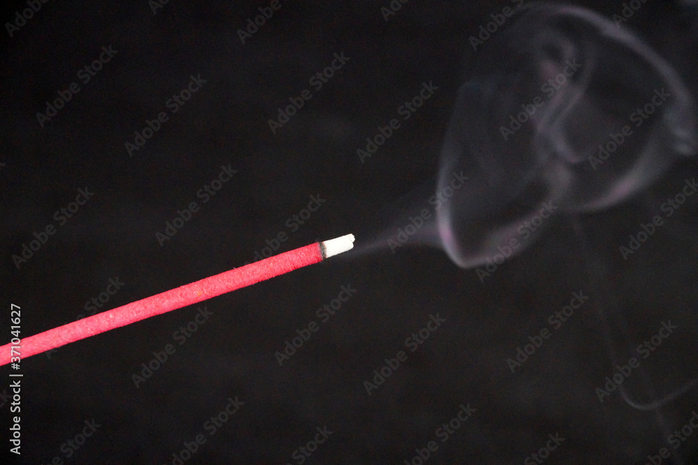 smoking incense stick on black background close up smoking incense stick on black background close up