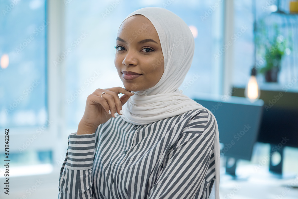 Muslim business lady wearing hijab and working at computer in office ...